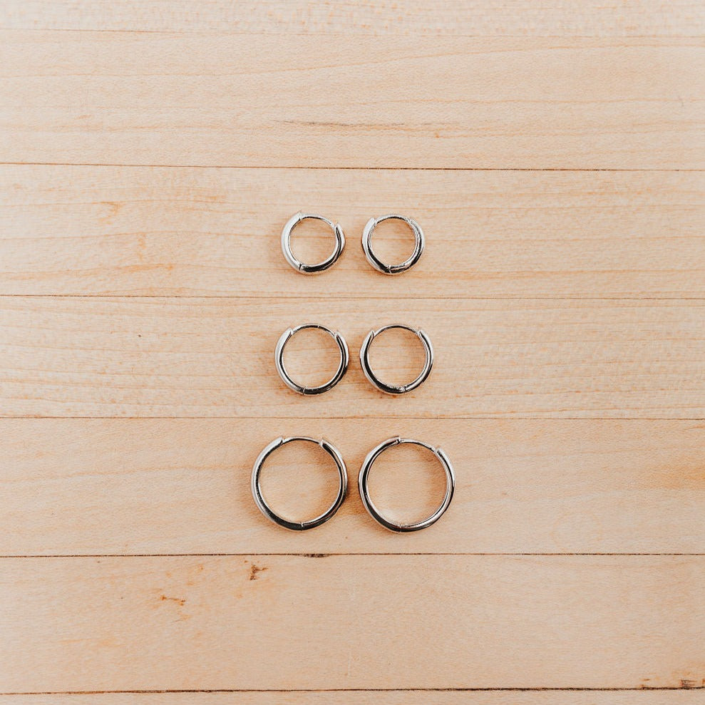 a row of silver rings on a wood surface