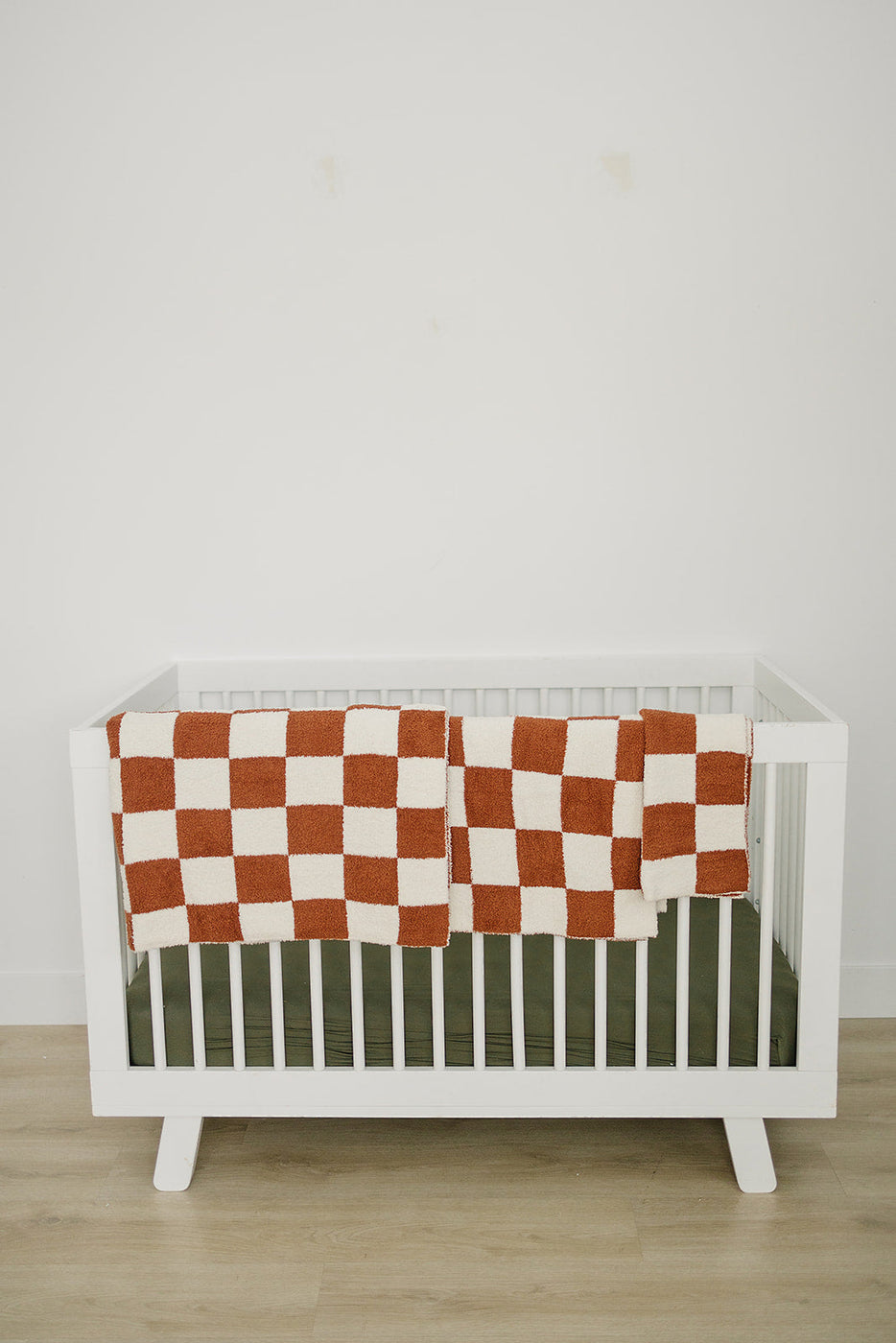 a crib with a checkered blanket