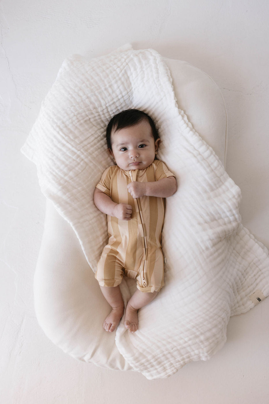 a baby lying in a white blanket