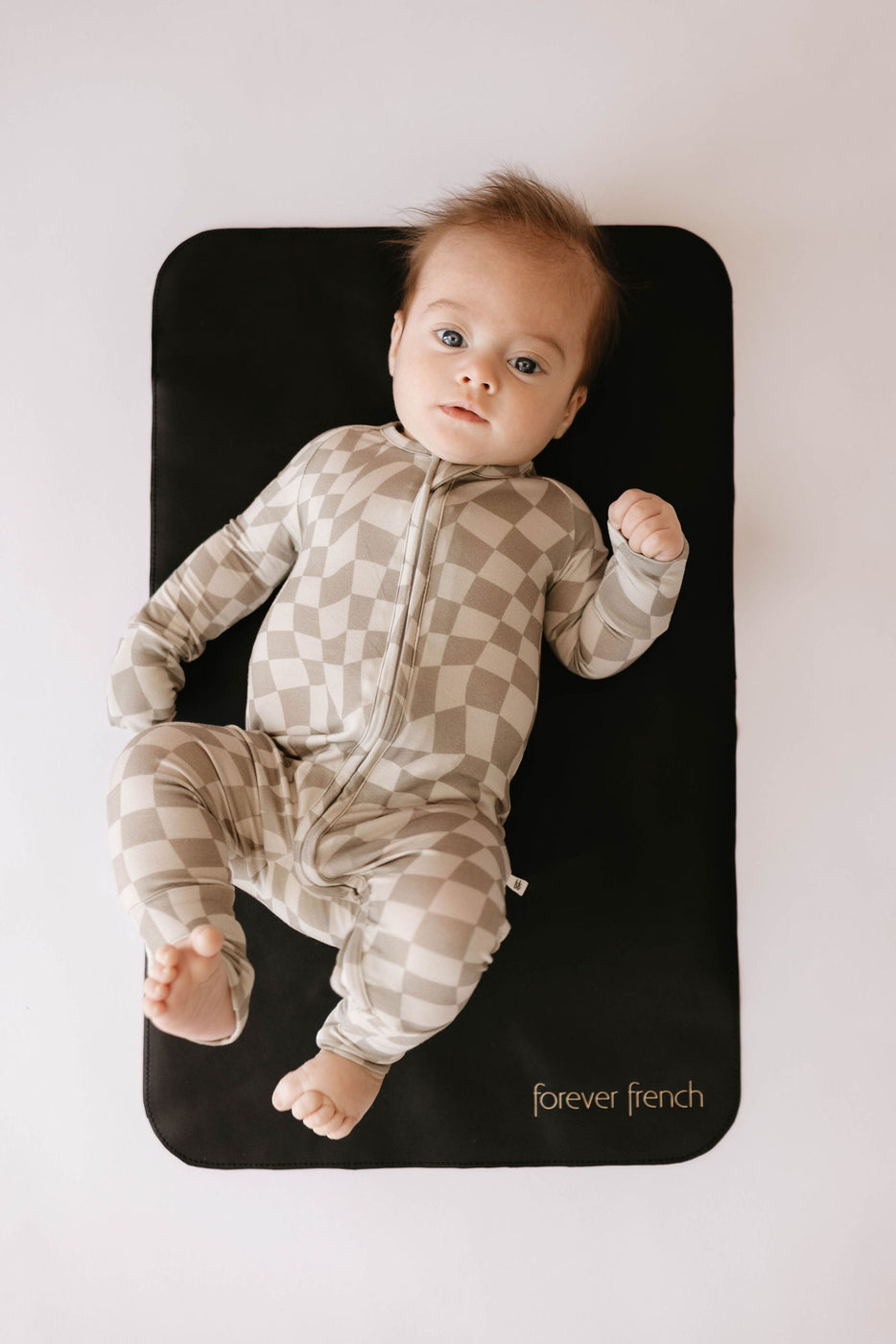 a baby lying on a black mat