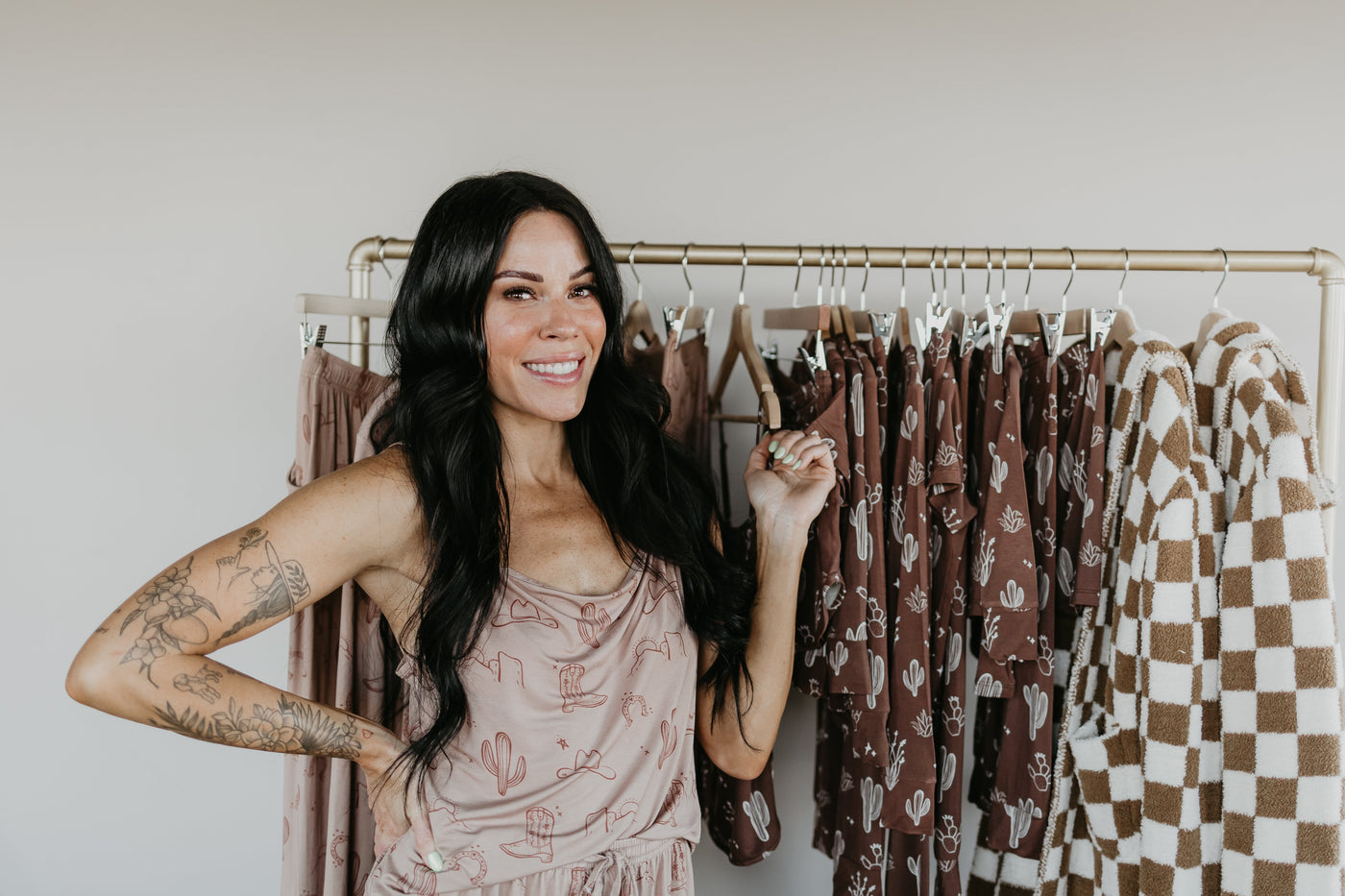 a woman standing in front of a rack of clothes