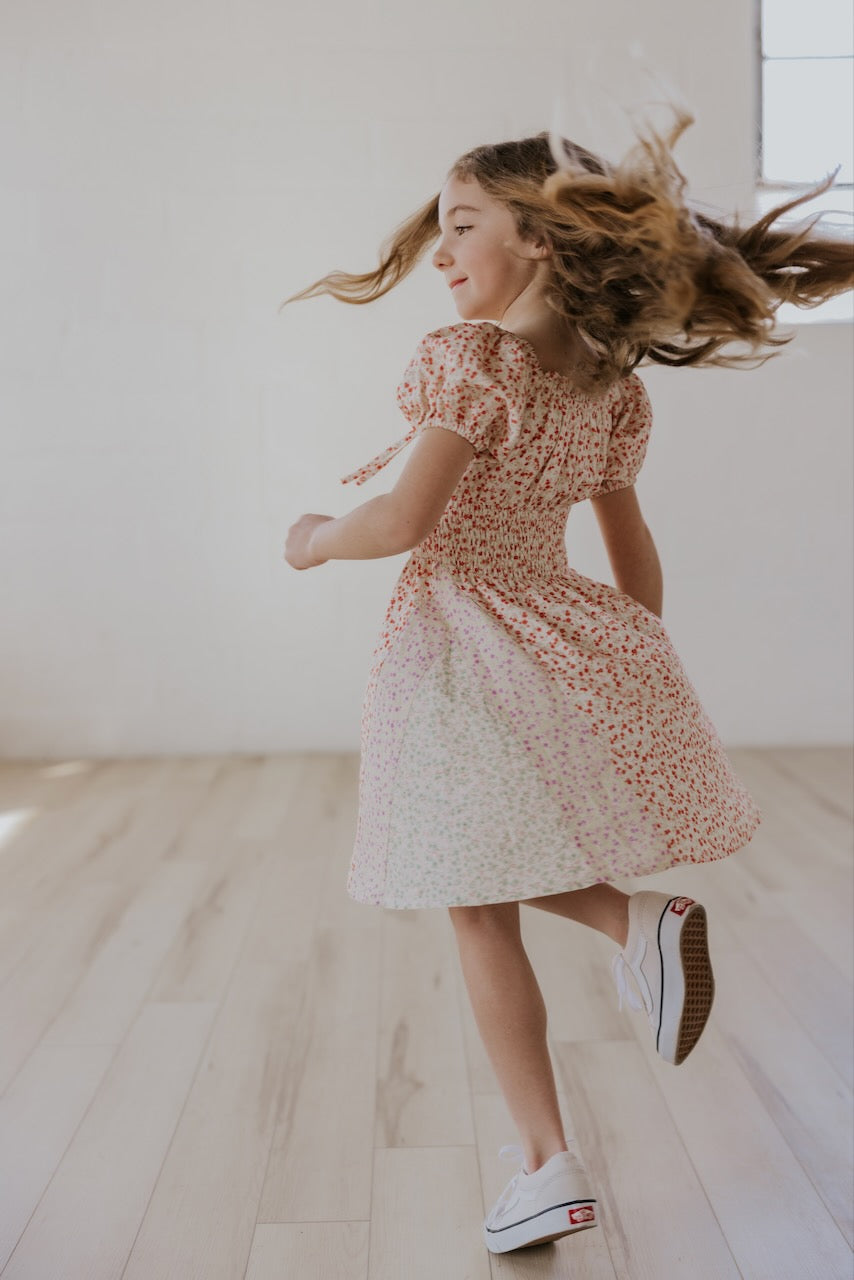 a girl in a dress and sneakers jumping