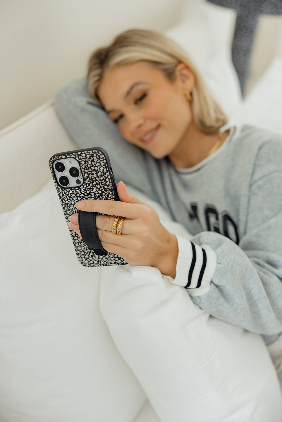 a woman lying on a bed holding a phone