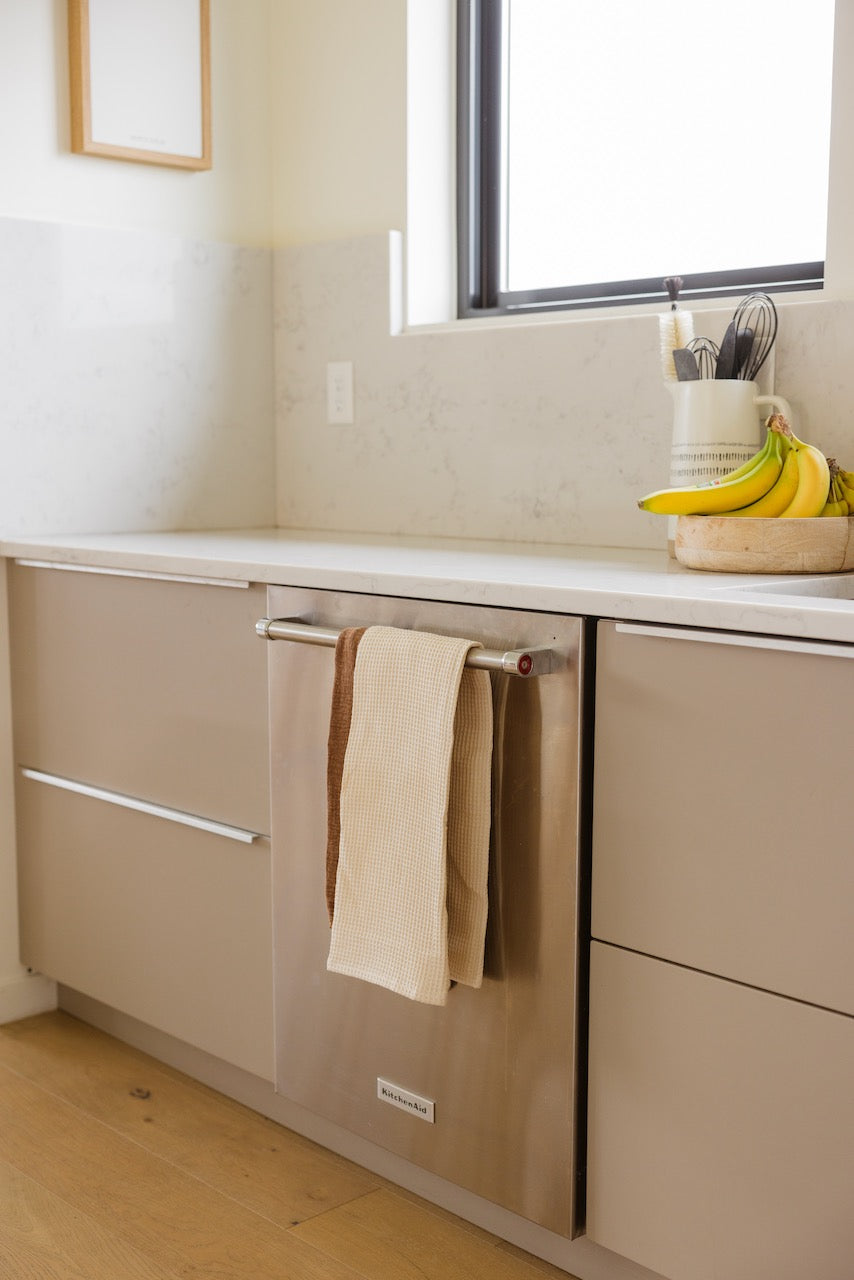 a kitchen counter with a dish towel and bananas