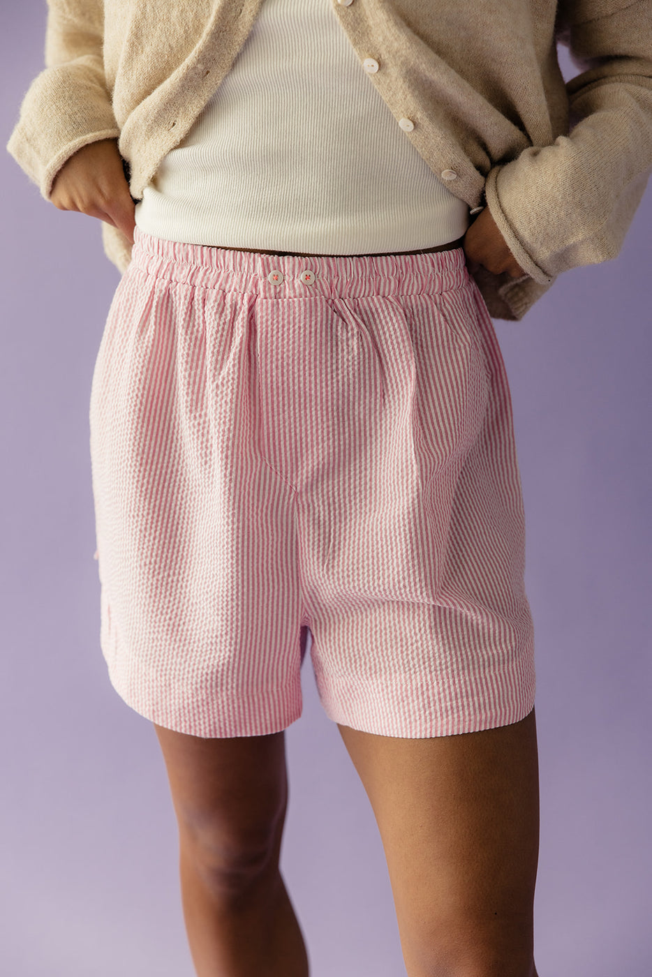 a person wearing a pair of pink and white striped shorts