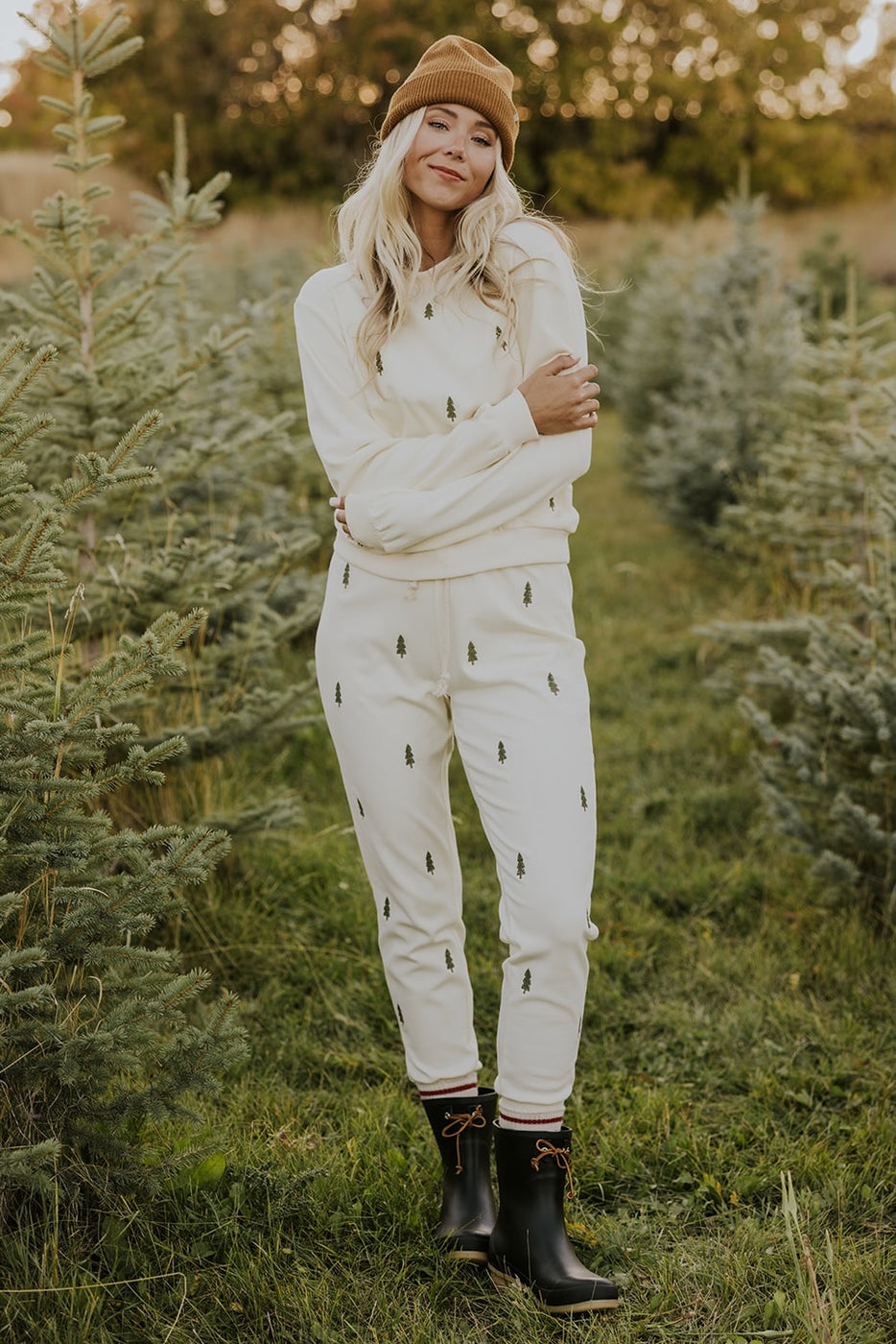 a woman standing in a field of trees