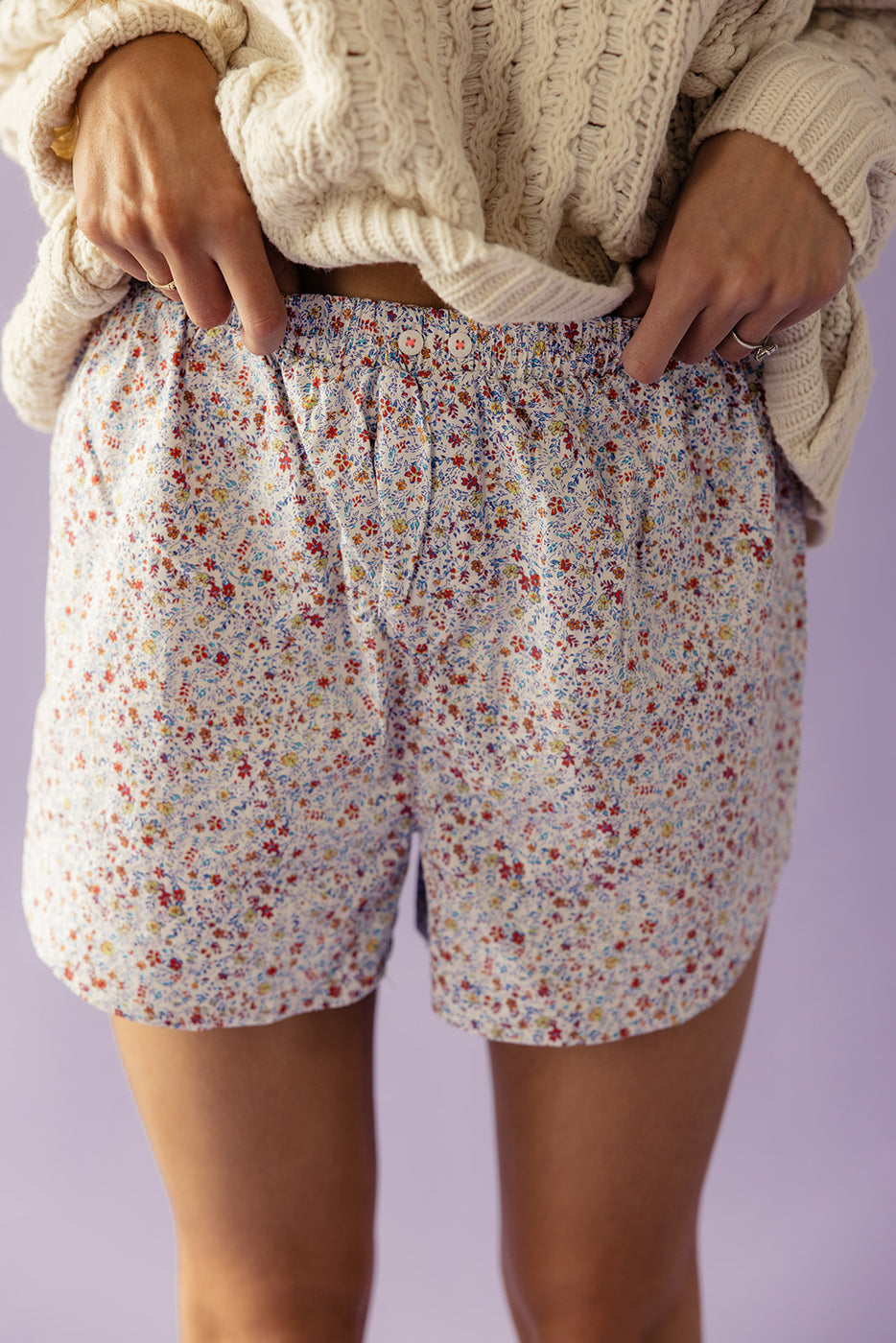a person wearing shorts with a flower pattern