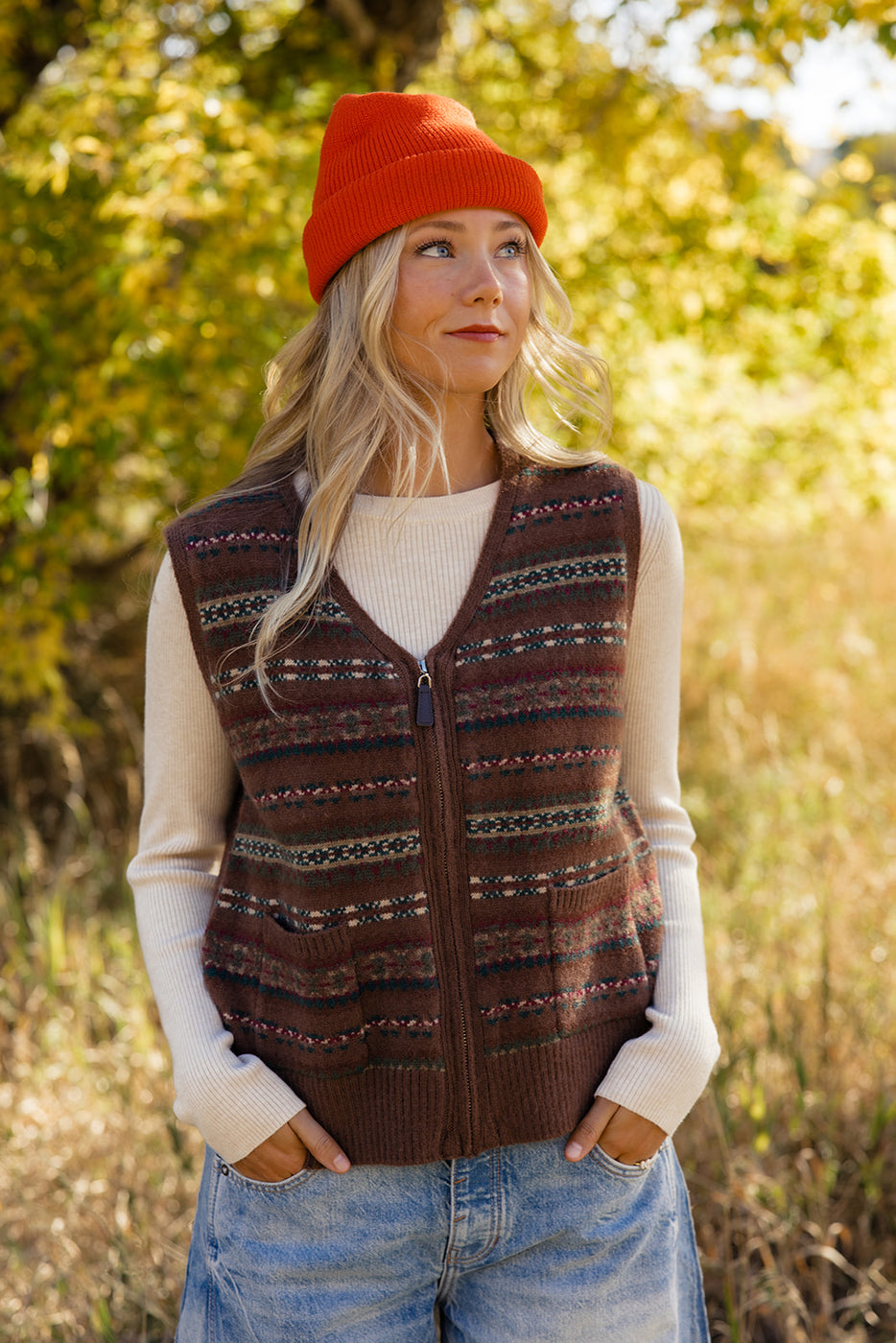 a woman in a vest and orange hat