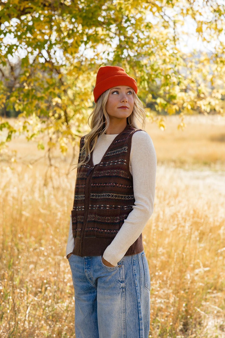 a woman in a hat and vest