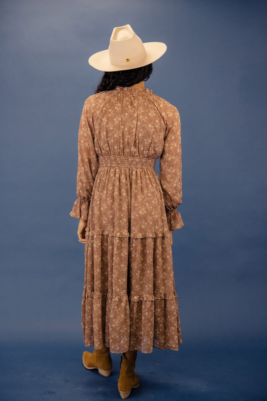 a woman in a brown dress and hat