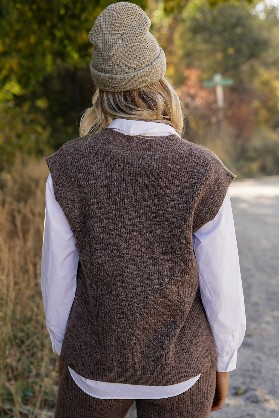 a woman wearing a hat and vest