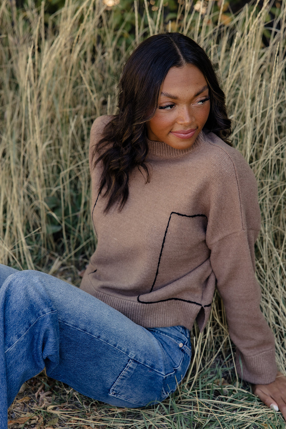 a woman sitting in tall grass