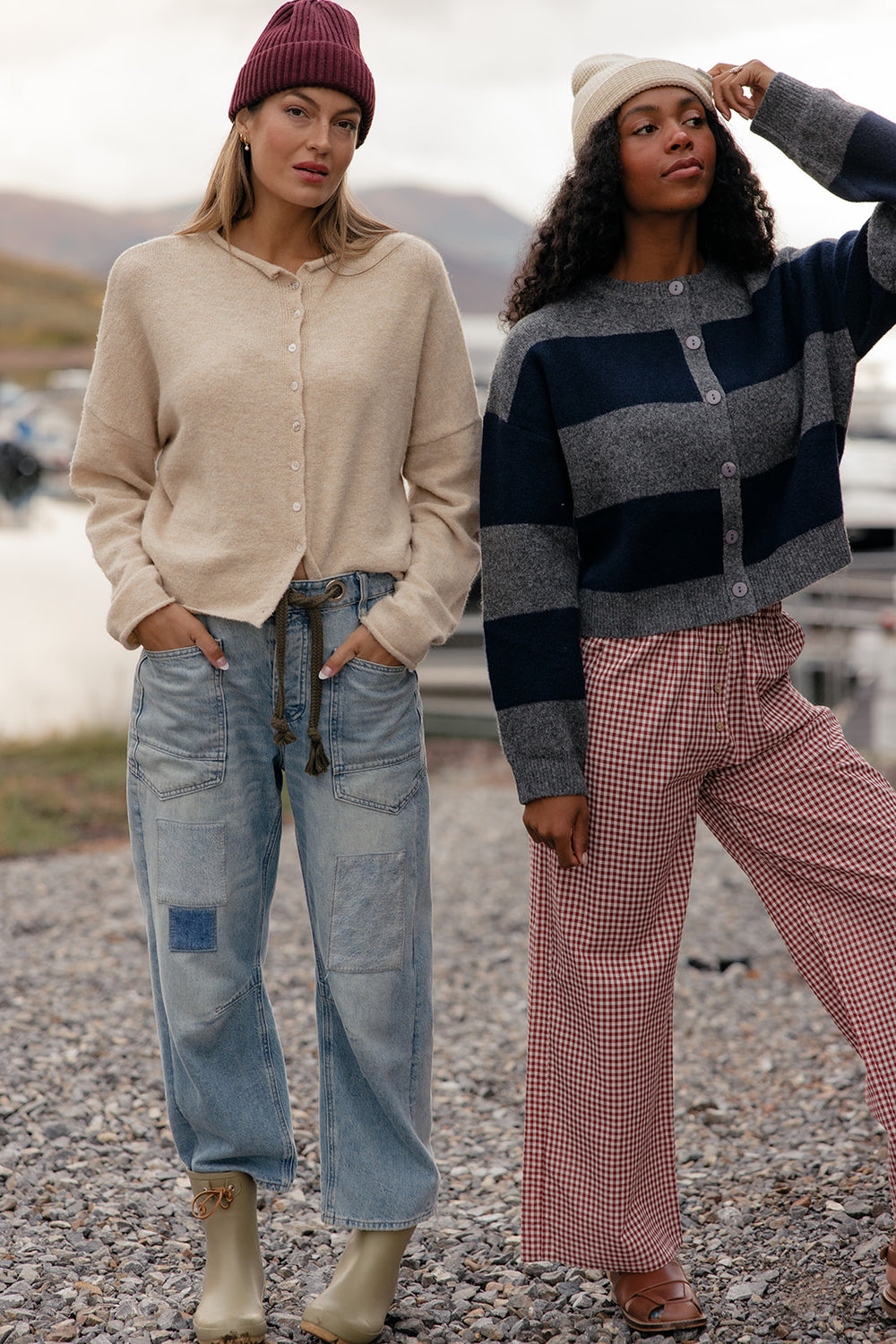 Two women standing outdoors wearing stylish clothing with a blurred background