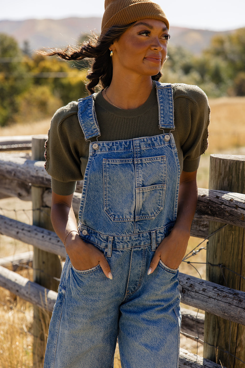 a woman standing in front of a fence