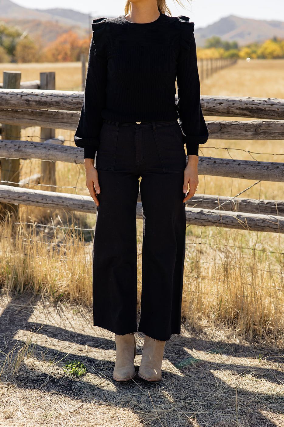 a woman standing in front of a fence