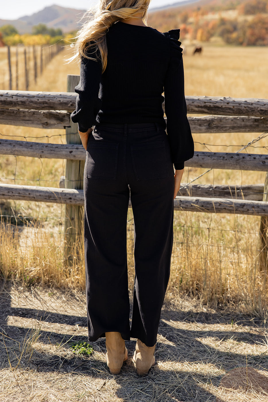 a woman standing in front of a fence