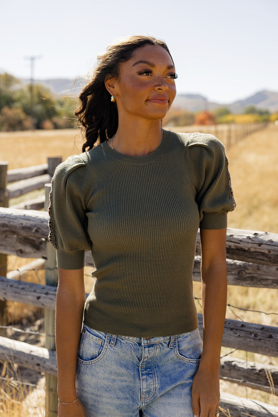 a woman standing in front of a fence