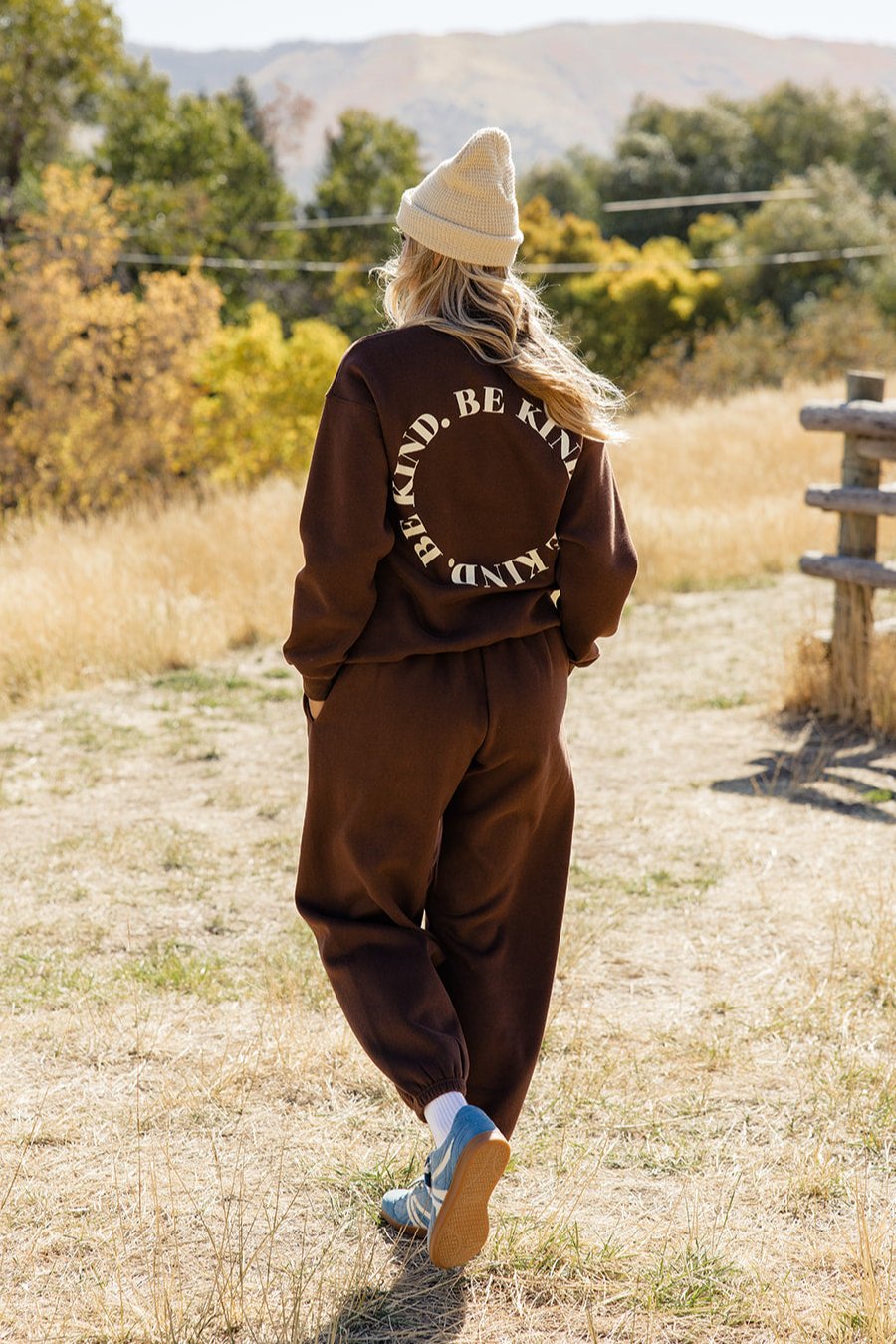 a woman wearing a hat and brown tracksuit