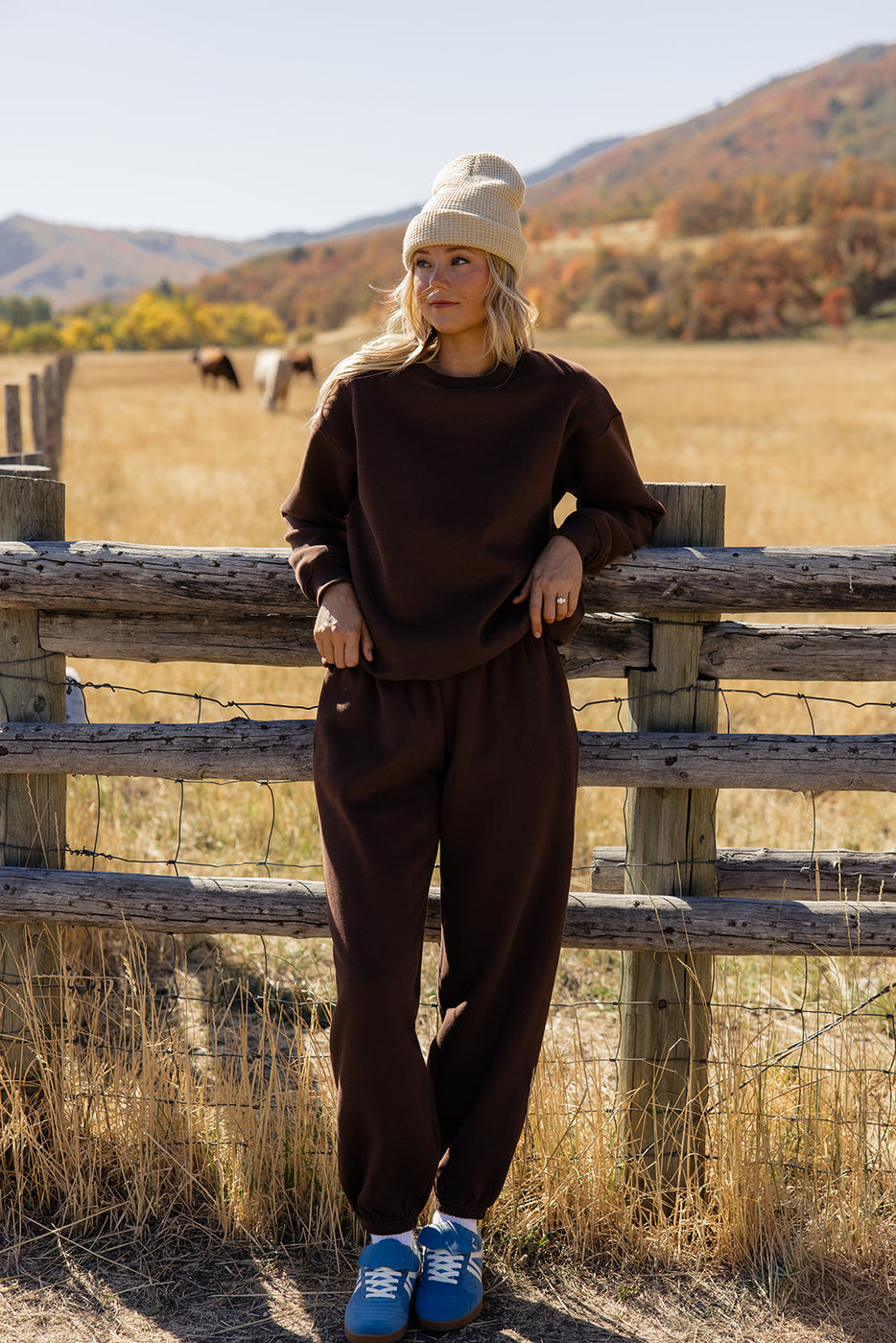 a woman leaning against a fence