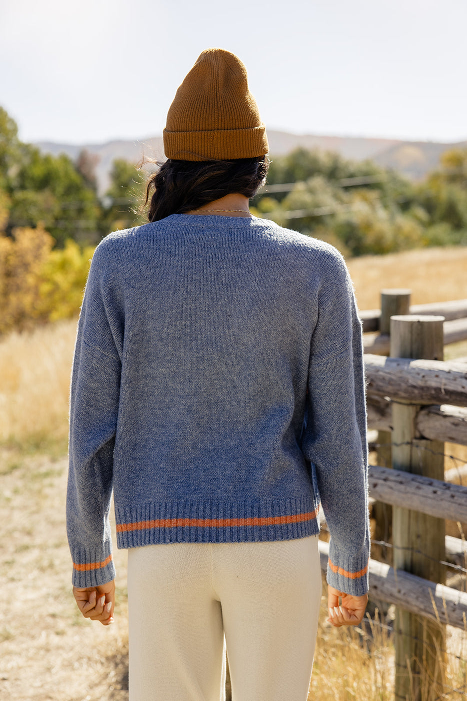 a woman wearing a sweater and hat