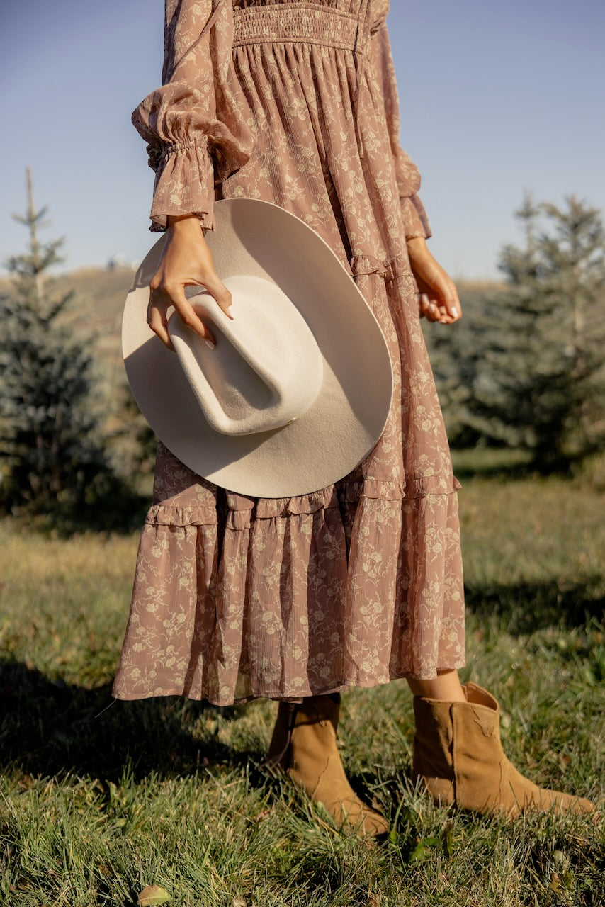 a woman wearing a dress and cowboy hat