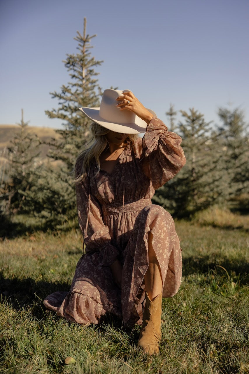 a woman in a dress and cowboy hat