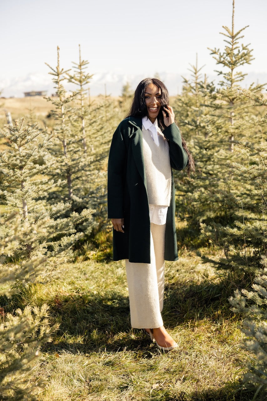 a woman standing in a field of trees