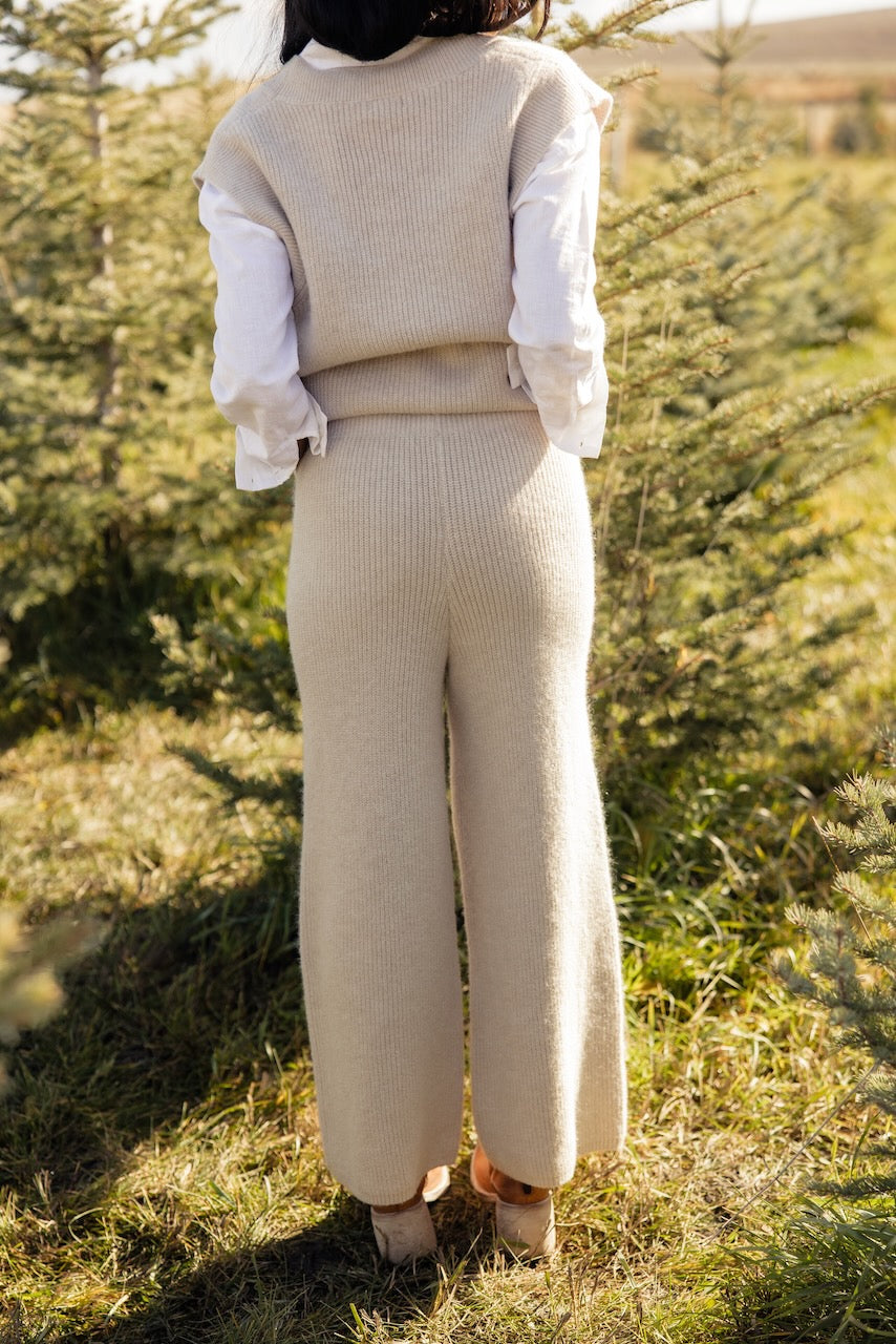 a woman wearing a sweater and pants