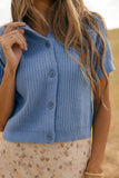 Woman wearing a blue knitted vest with a blurred background