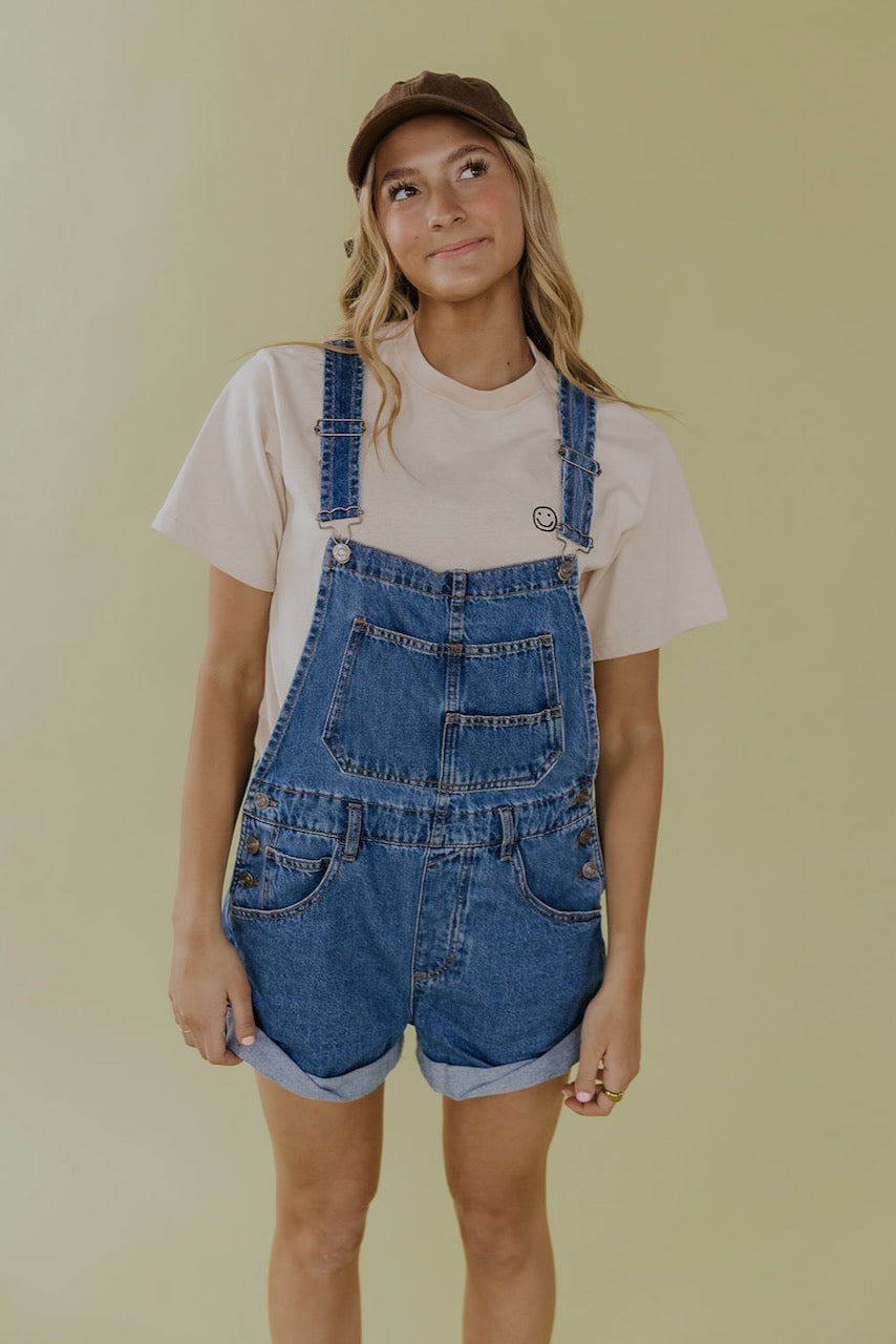 a woman in overalls smiling