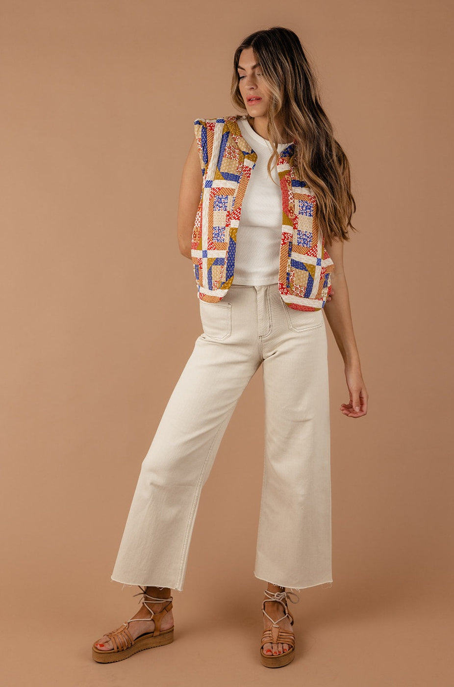 a woman in a vest and white pants