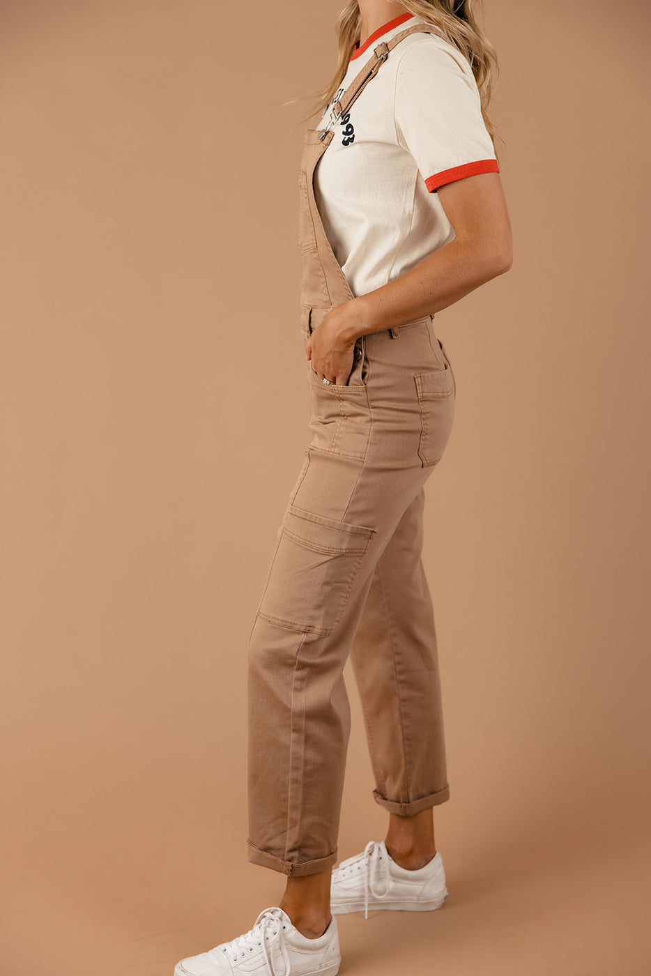a woman in a white shirt and brown overalls