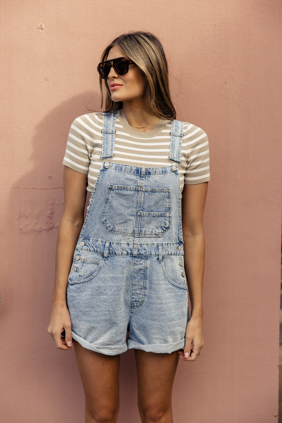 a woman wearing sunglasses and overalls