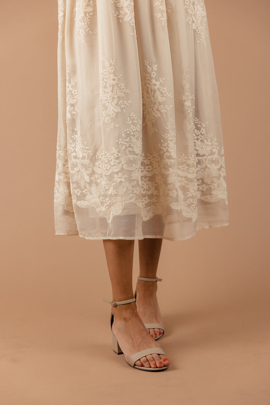 a woman wearing a white dress and sandals