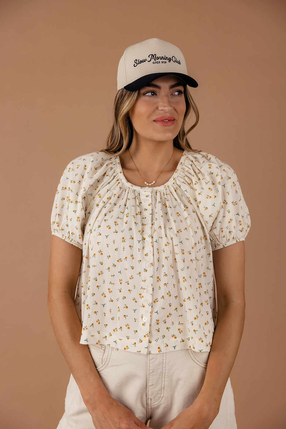 a woman wearing a hat and a blouse