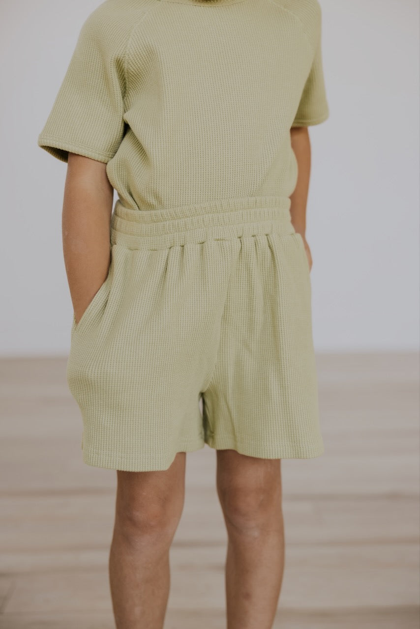 a child wearing a green outfit