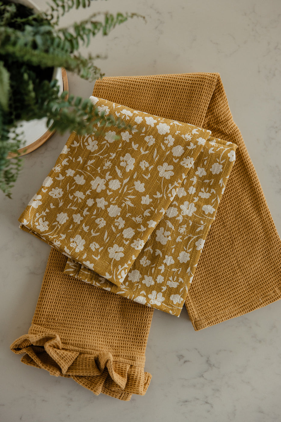 a folded yellow towel with white flowers on it