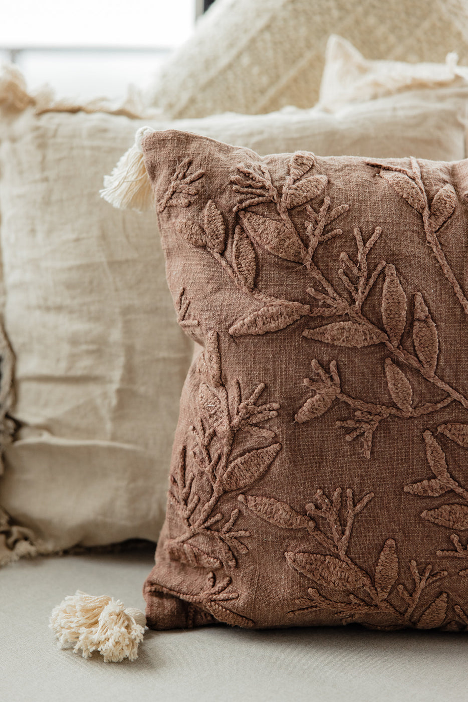 a brown pillow with a tassel