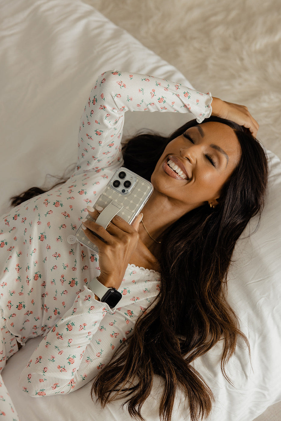 a woman lying on a bed holding a phone