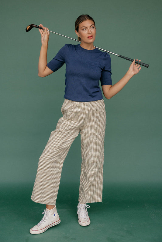 Woman holding a golf club against a green background