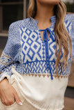 Close-up of a person wearing a blue and white patterned sweater with a blurred background