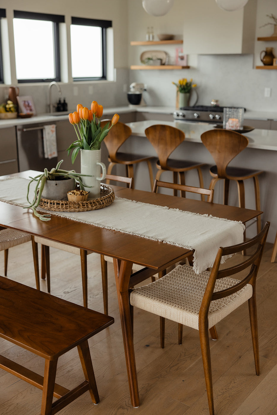 a table with chairs and a vase of flowers