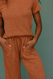 Person wearing a brown outfit with a plain background