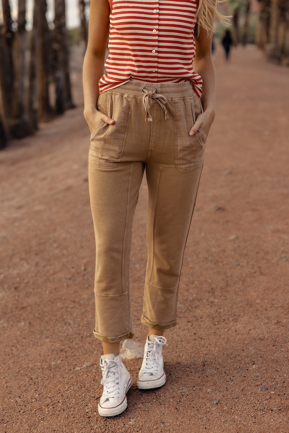 a person wearing tan pants and white shoes