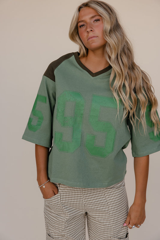 Person wearing a green sports jersey with the number 95 on a plain background