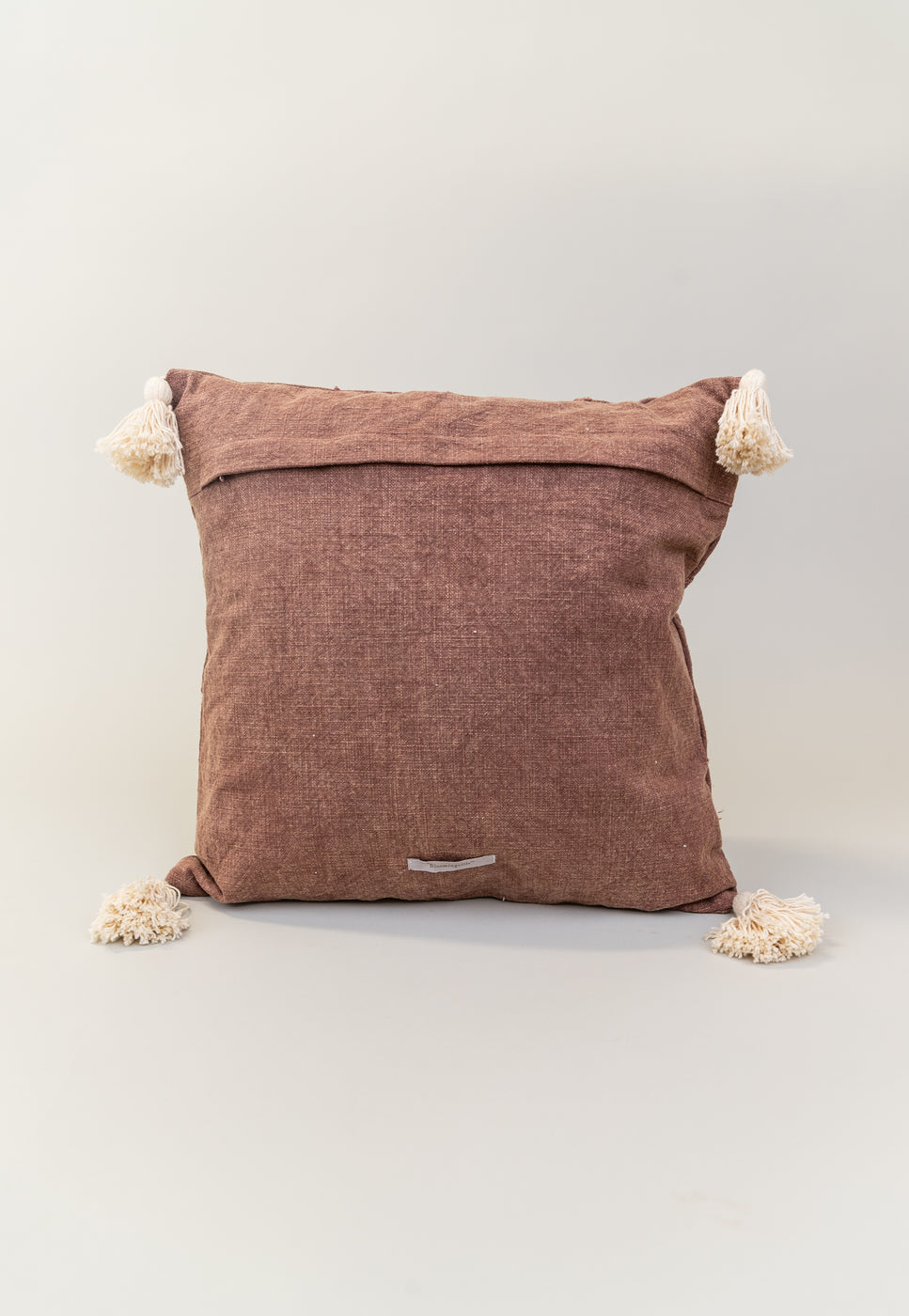 a brown pillow with tassels