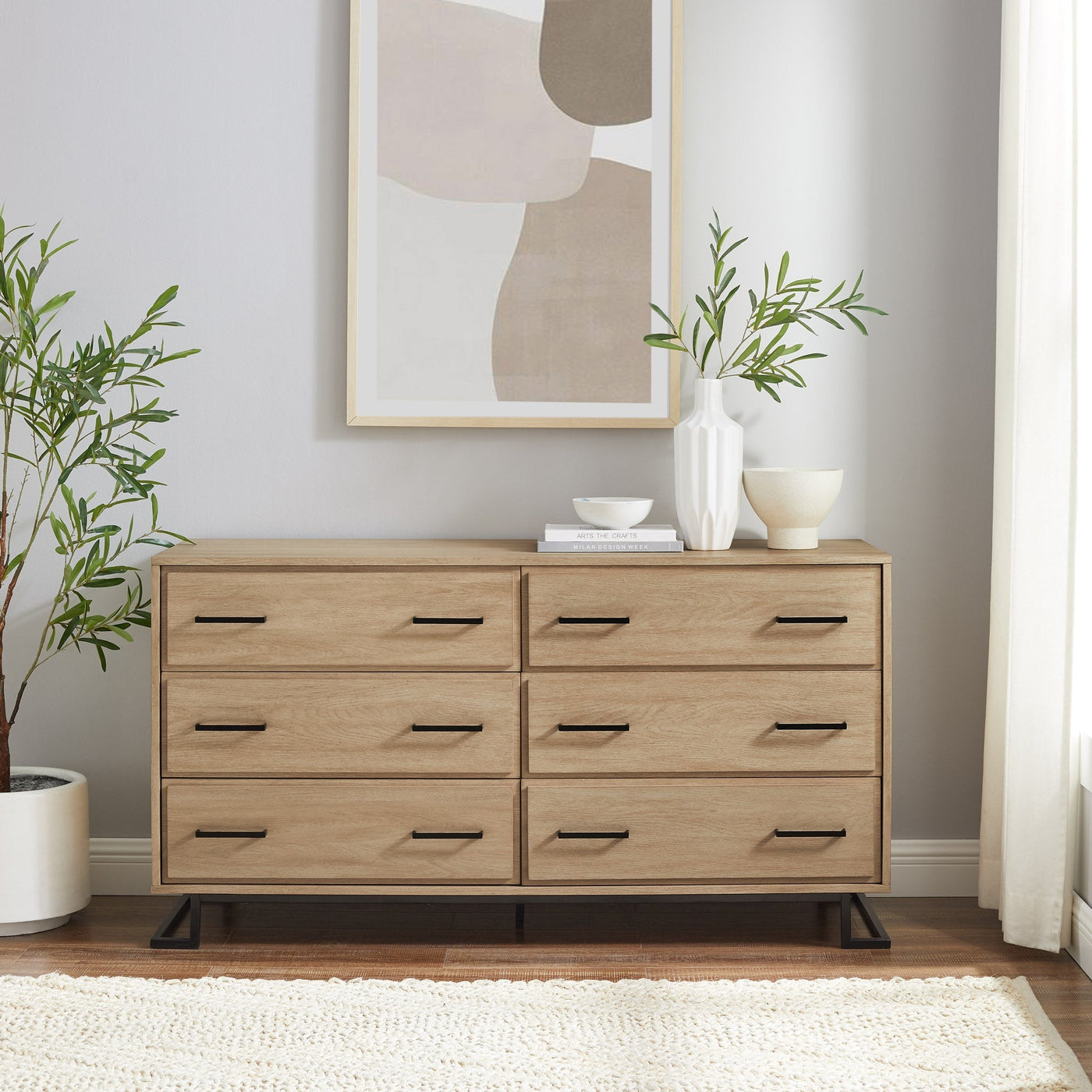 a dresser with a painting on the wall