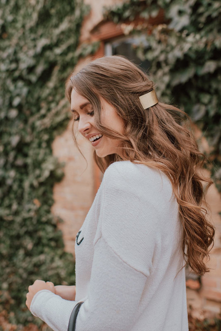 a woman smiling with a gold hair clip