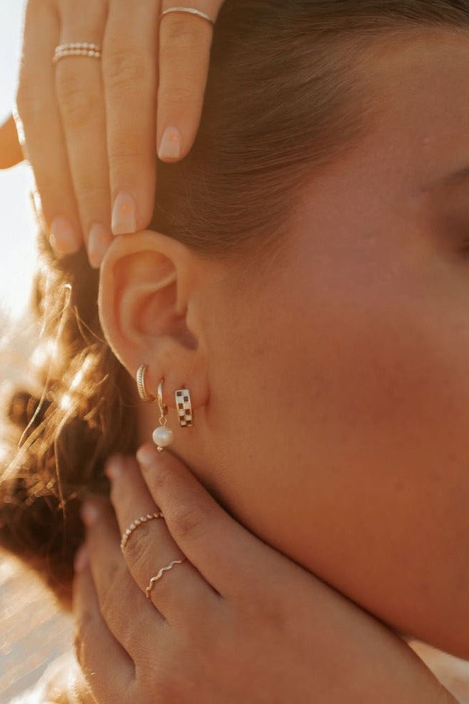a woman with her hands on her ear