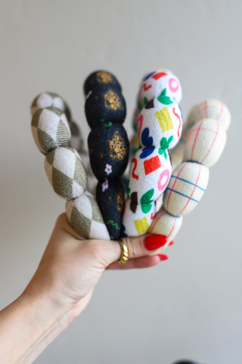 a hand holding a group of fabric balls